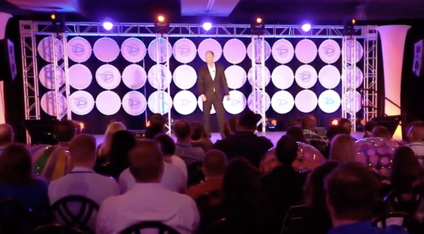 Tim Shurr on stage in front of a full conference room