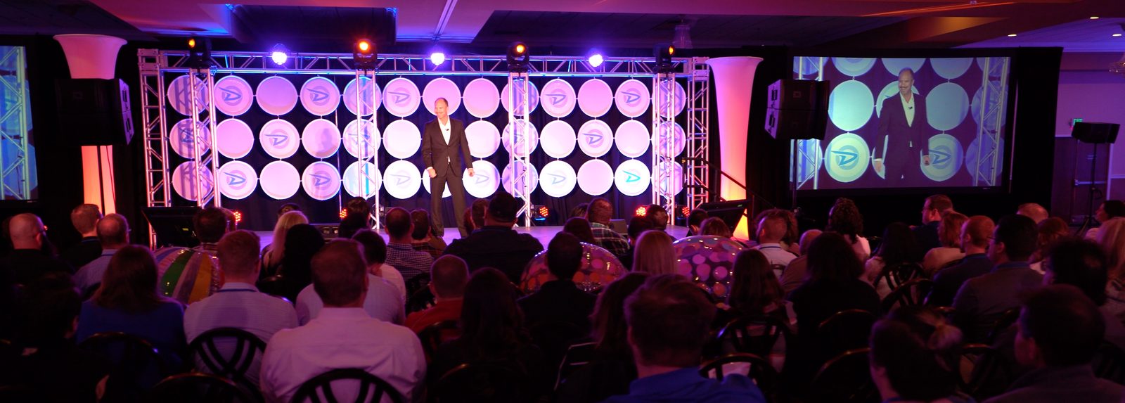 Tim Shurr on stage at a corporate conference with a full ballroom audience